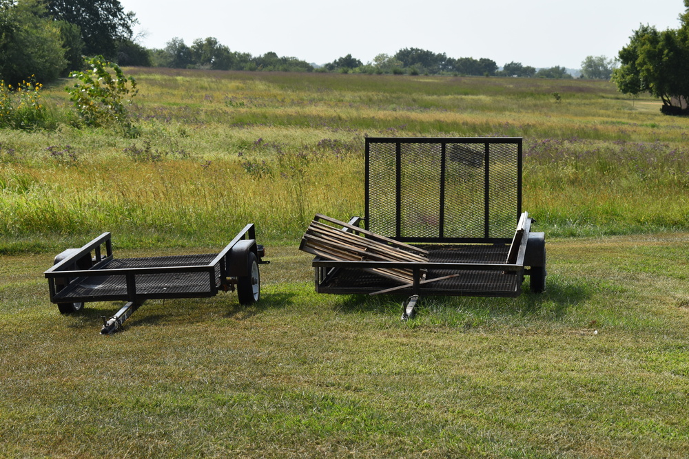 Two trailers ready for a trailer trade in on the grass.