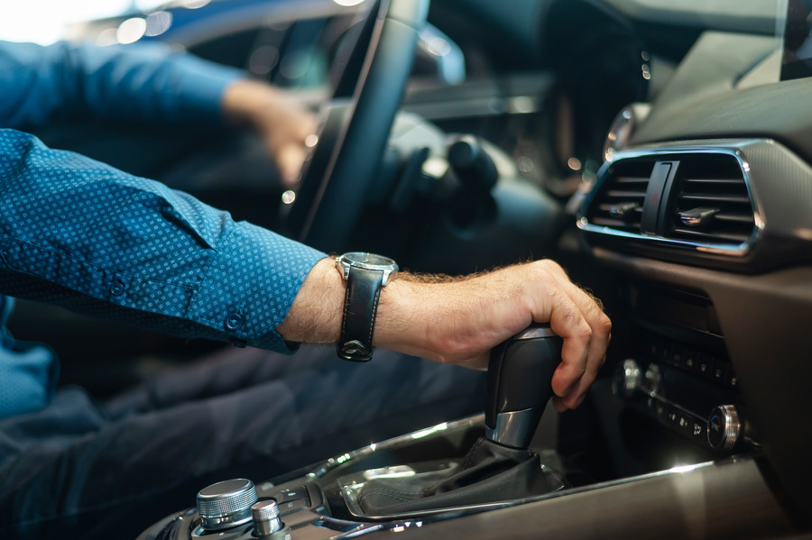 A man shifts gears to reverse his vehicle and trailer.